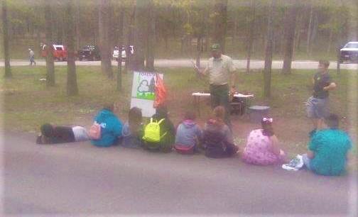 Kids and presenter gathered at the forestry  station at the Eco Day at the Piney Wood Rec Area
